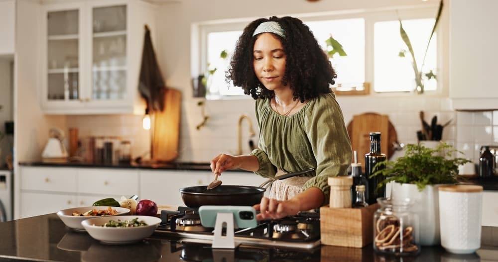 Mulher cozinhando usando o serviço Nutri+ da TotalPass.
