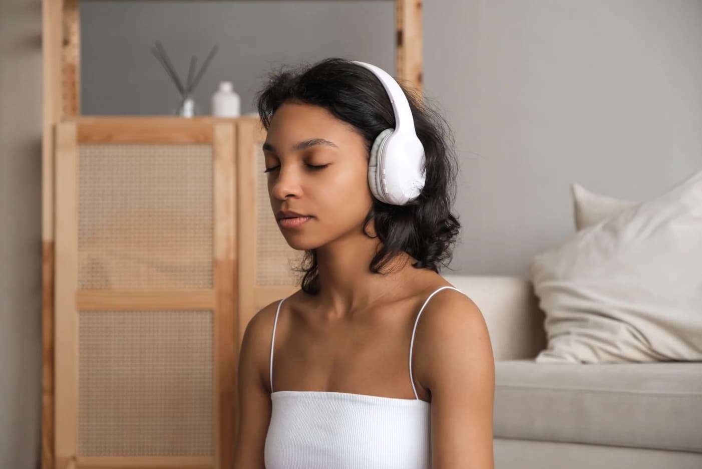 Zen App A imagem tem uma menina com headphone. Ela está no seu quarto, concentrada e de olhos fechados.